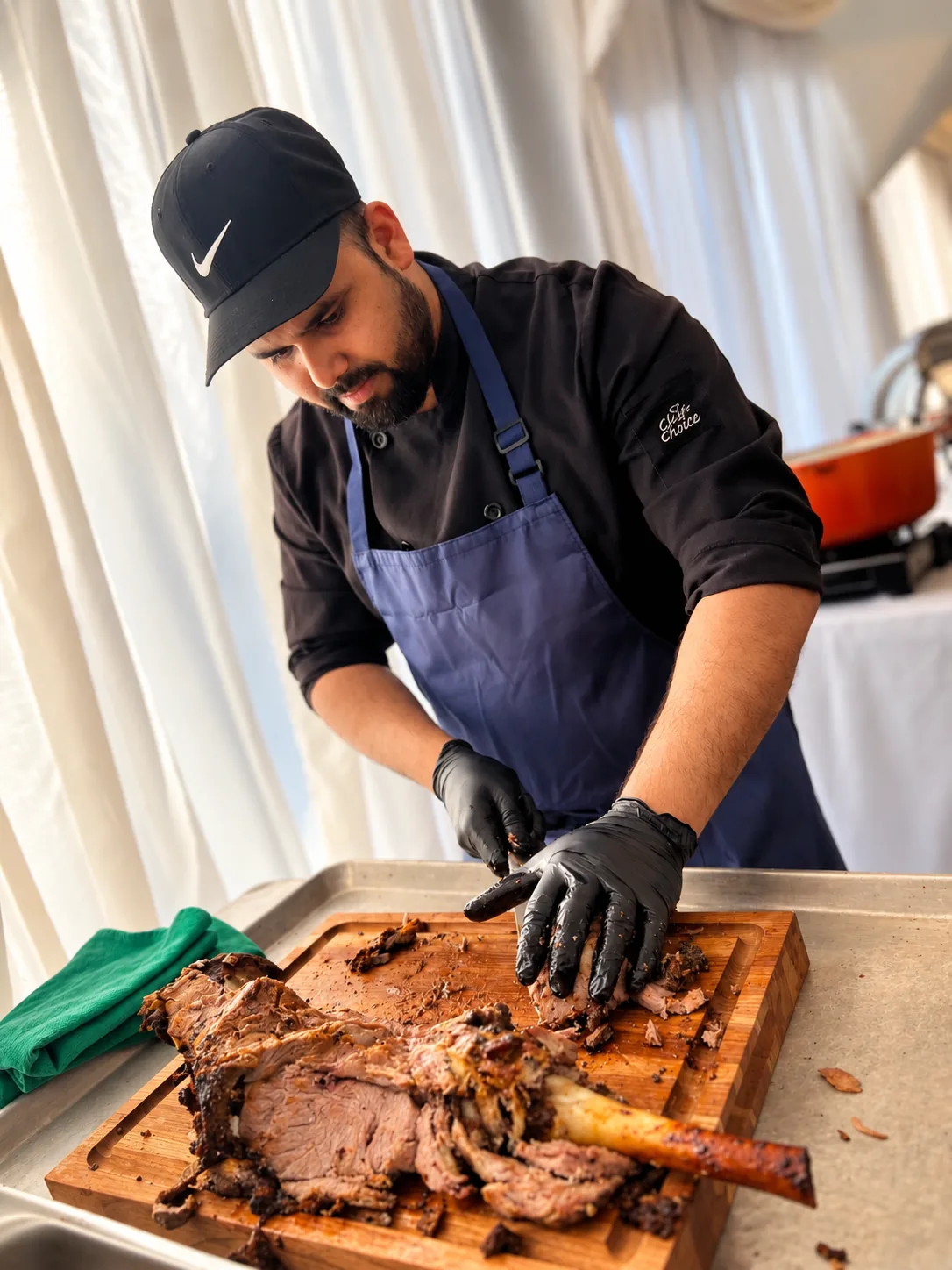 A chef carving a rack of lamb at a station