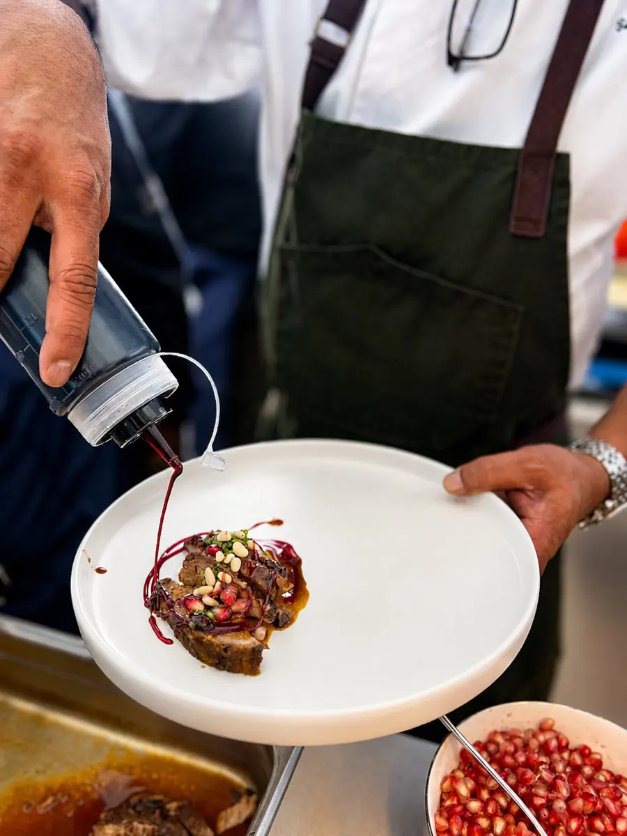 A Cleese chef finishing a plate