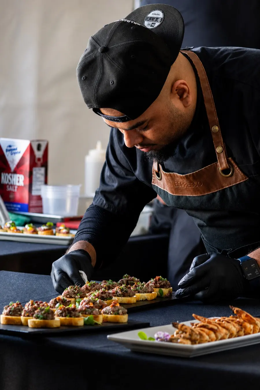 A chef plating canapés at a station
