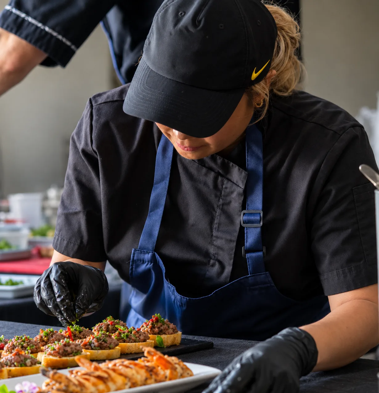 A cook garnishing canapés in the Cleese kitchen