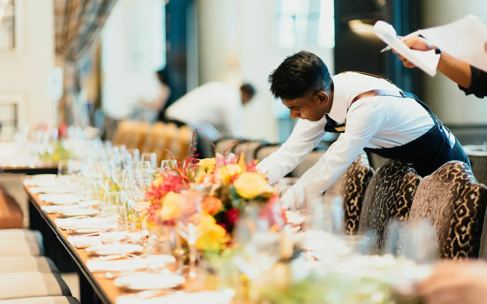 A server laying out a table of canapés before a reception