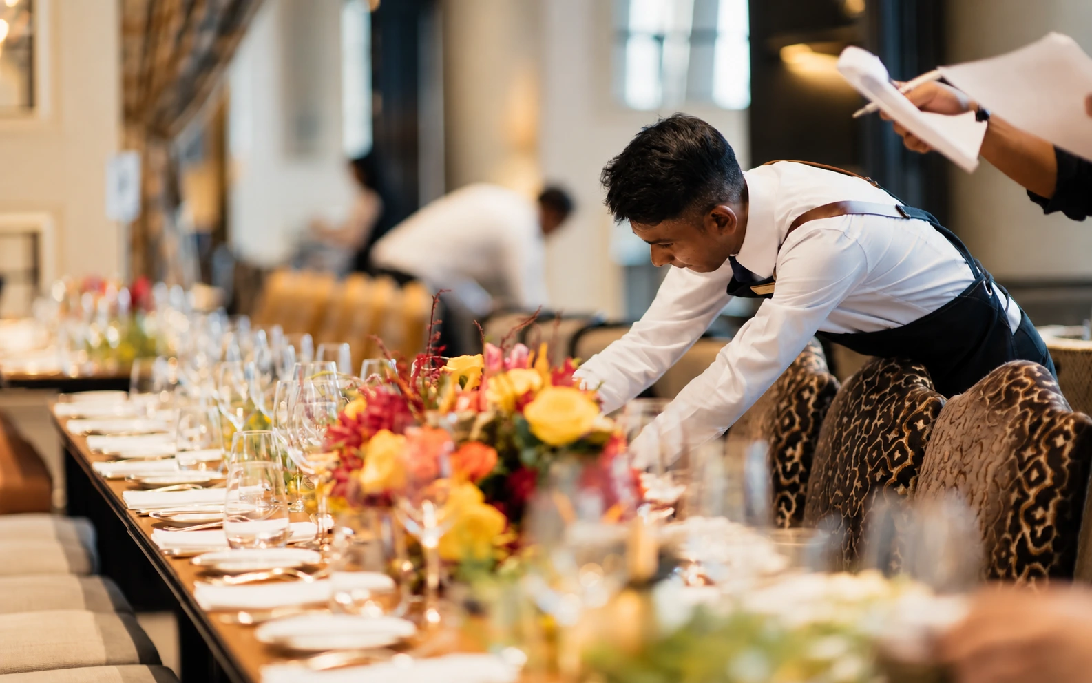 A server laying out a table of canapés before a reception